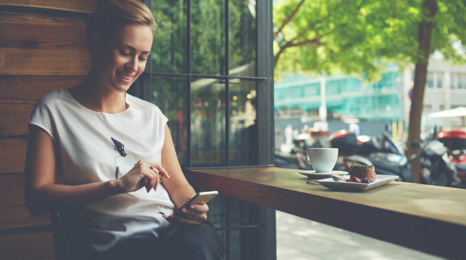 Charming Woman With Beautiful Smile Reading Good News On Mobile Phone